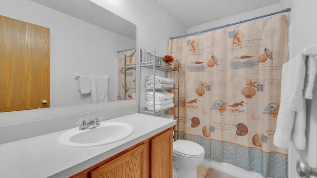 bathroom with a textured ceiling, vanity, and toilet