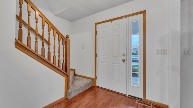 entrance foyer with light hardwood / wood-style flooring and a textured ceiling