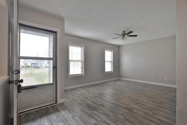 spare room with ceiling fan, dark wood-type flooring, and a textured ceiling