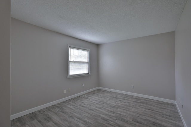 unfurnished room featuring a textured ceiling and hardwood / wood-style flooring