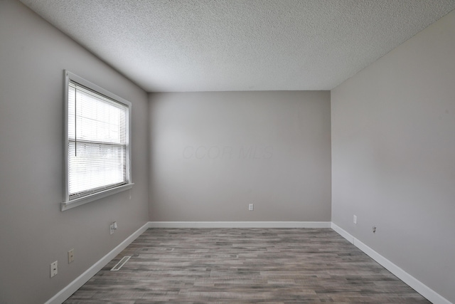 empty room featuring hardwood / wood-style floors and a textured ceiling