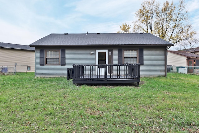 rear view of property with a wooden deck and a yard