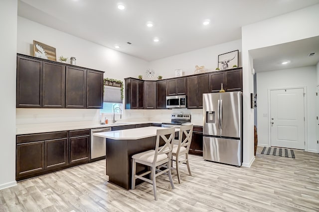 kitchen featuring a center island, sink, appliances with stainless steel finishes, and light hardwood / wood-style flooring