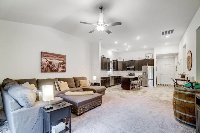 carpeted living room with ceiling fan, sink, and lofted ceiling