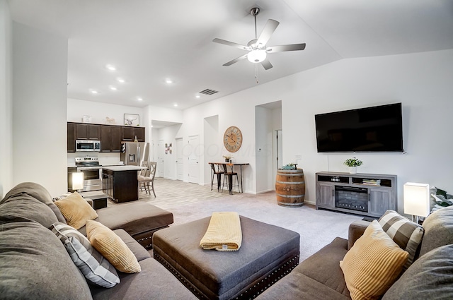 living room with light carpet, ceiling fan, and vaulted ceiling