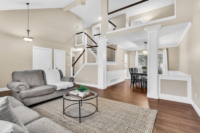 living room with dark hardwood / wood-style floors, high vaulted ceiling, decorative columns, and crown molding