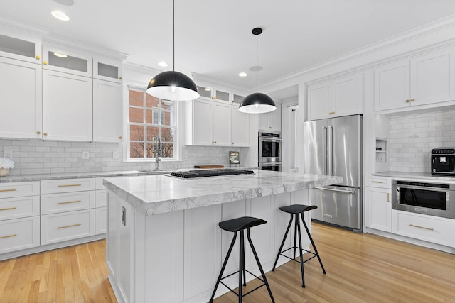 kitchen featuring appliances with stainless steel finishes, sink, a kitchen island, and white cabinets