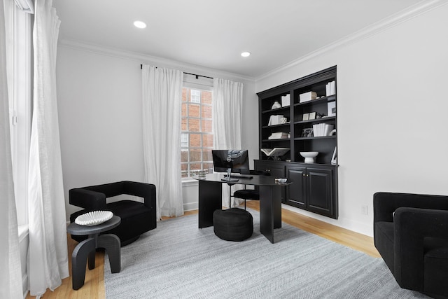 home office with ornamental molding and light hardwood / wood-style flooring