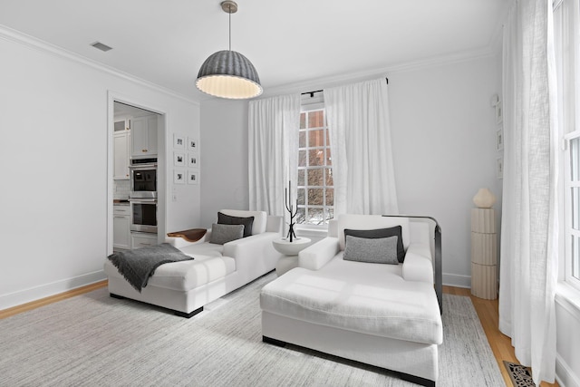 living room with crown molding and light hardwood / wood-style flooring