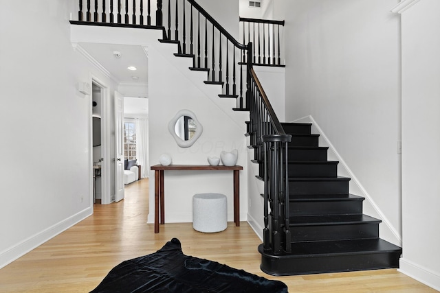 staircase featuring hardwood / wood-style flooring and crown molding