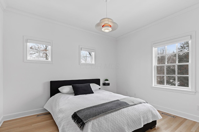 bedroom with crown molding and light hardwood / wood-style floors