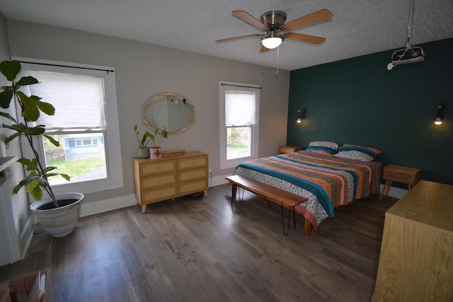bedroom featuring ceiling fan, wood finished floors, and a textured ceiling