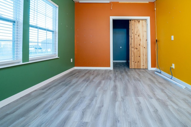 unfurnished bedroom featuring light wood-type flooring and a closet