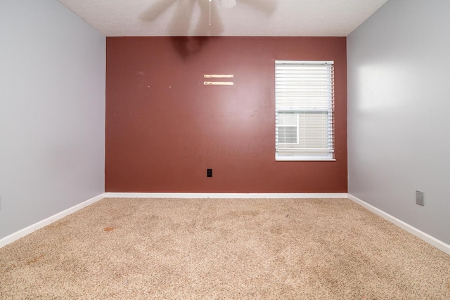 carpeted spare room featuring ceiling fan and a textured ceiling