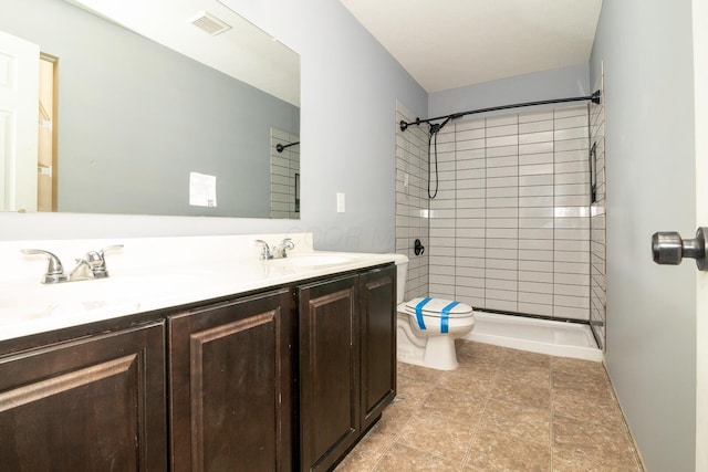 bathroom featuring vanity, toilet, and tiled shower