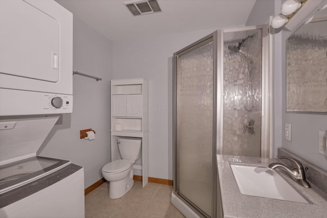 bathroom with sink, tile patterned flooring, stacked washer and dryer, toilet, and a shower with door