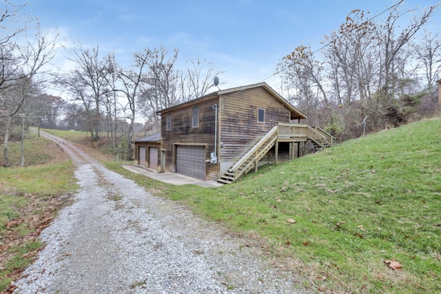 view of side of home featuring a garage and a deck