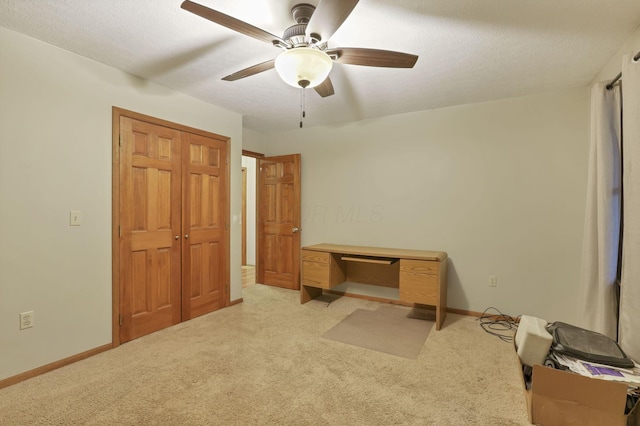 unfurnished bedroom with ceiling fan, light colored carpet, a textured ceiling, and a closet