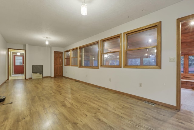 unfurnished living room featuring light hardwood / wood-style floors and a healthy amount of sunlight