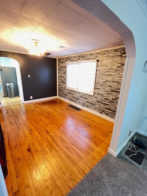 empty room featuring crown molding and hardwood / wood-style floors