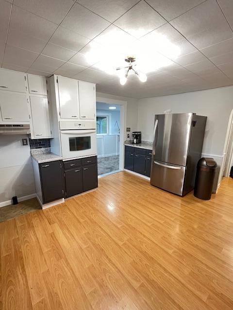 884 Rapp-Montgomery Rd Unit C627, Lucasville, OH 45648 - kitchen with freestanding refrigerator, oven, white cabinets, light wood-style flooring, and light countertops