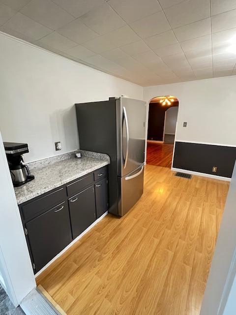884 Rapp-Montgomery Rd Unit C627, Lucasville, OH 45648 - kitchen with arched walkways, dark cabinets, freestanding refrigerator, light wood finished floors, and light countertops