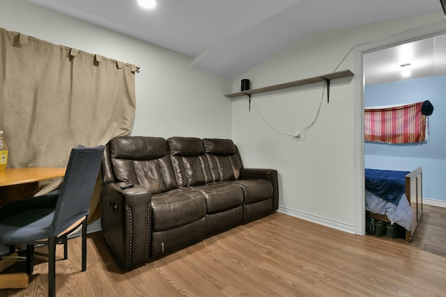 living room with light hardwood / wood-style floors and vaulted ceiling