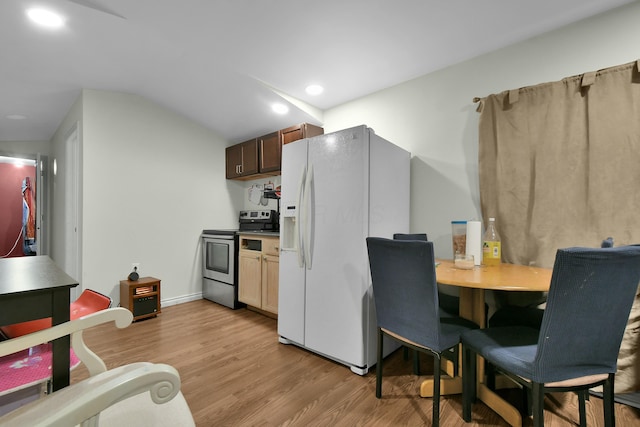 kitchen featuring vaulted ceiling, light hardwood / wood-style flooring, stainless steel range with electric cooktop, and white refrigerator with ice dispenser