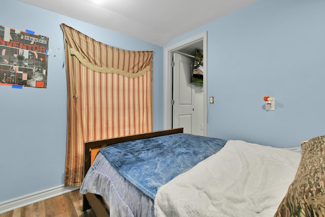 bedroom with wood-type flooring and lofted ceiling