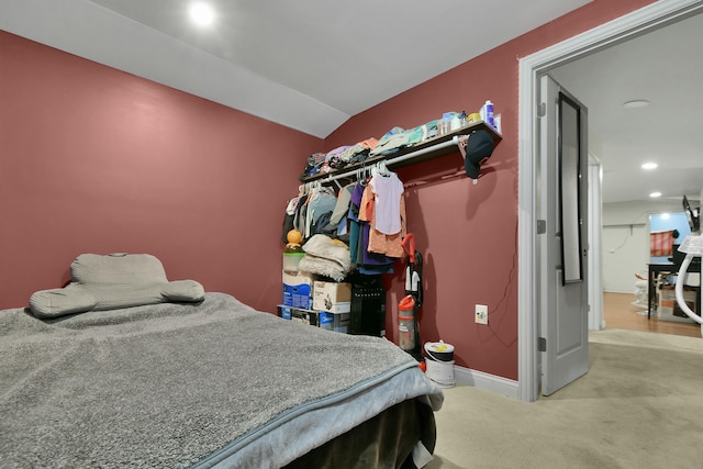 bedroom with light carpet and vaulted ceiling