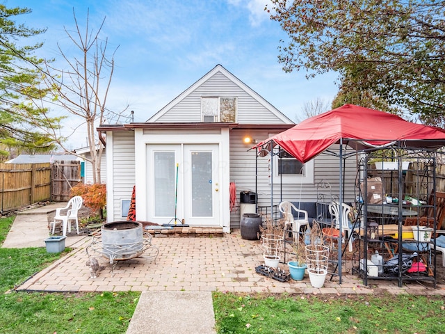 rear view of house with a gazebo, an outdoor fire pit, and a patio area