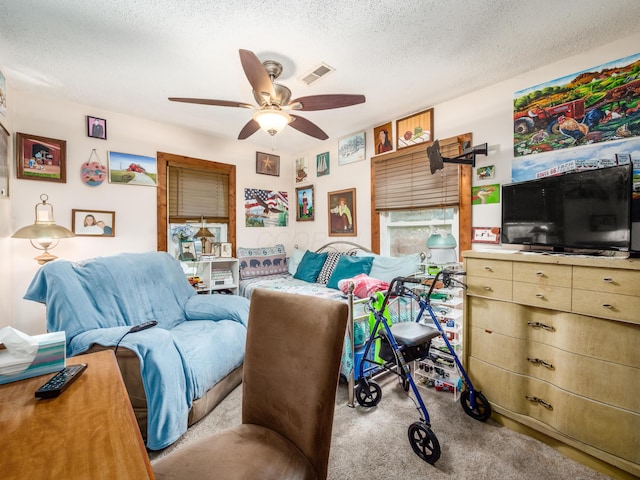 living room with a textured ceiling, light colored carpet, and ceiling fan