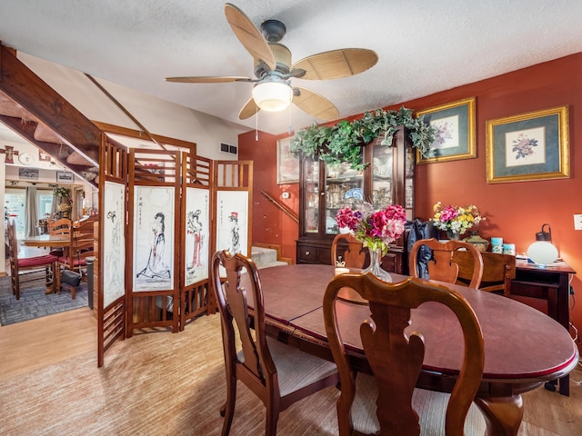 dining space with a textured ceiling, light hardwood / wood-style flooring, and ceiling fan