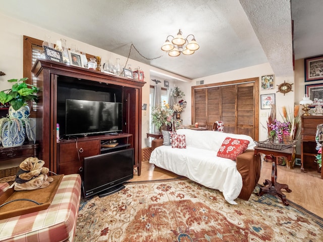 bedroom featuring a closet, a textured ceiling, and light hardwood / wood-style flooring