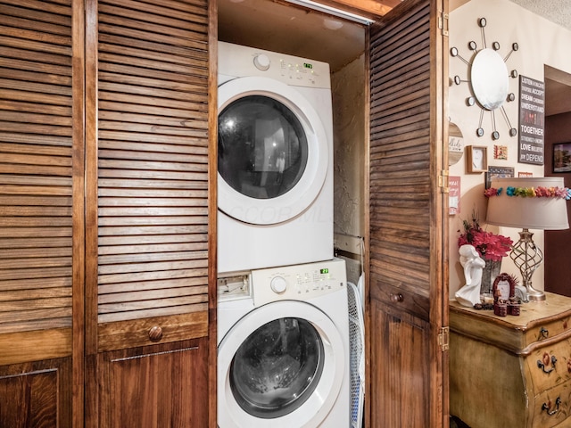 washroom featuring stacked washer and clothes dryer