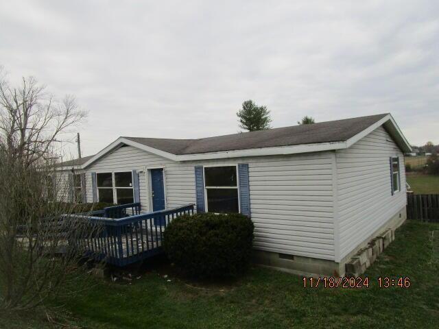 rear view of house with a lawn and a deck