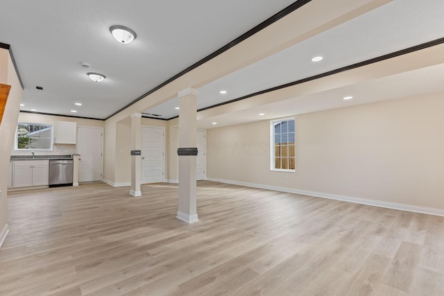 unfurnished living room with crown molding, sink, and light wood-type flooring