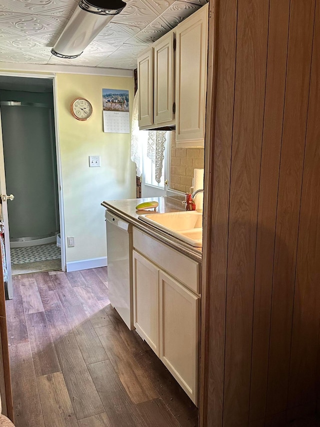 kitchen with stainless steel dishwasher, dark hardwood / wood-style flooring, sink, and tasteful backsplash