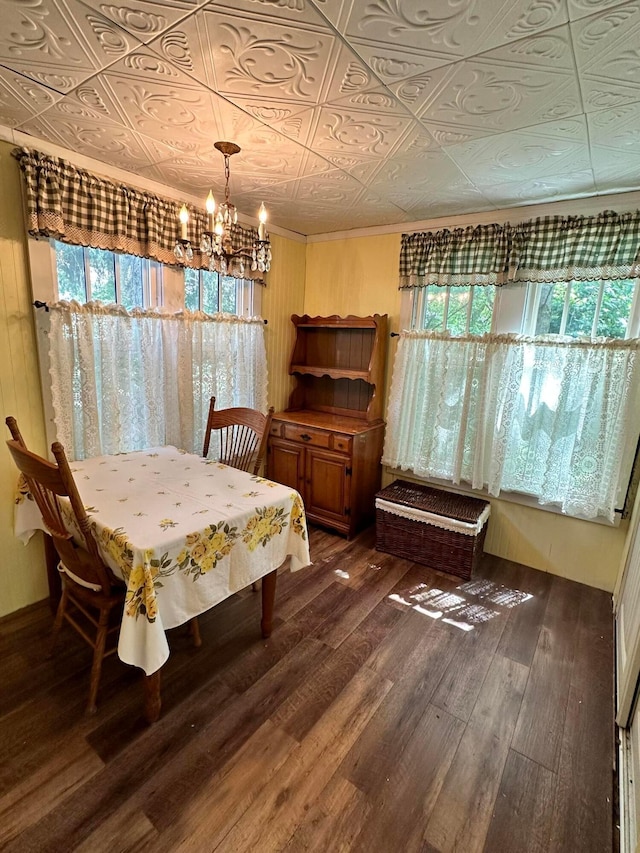 dining room with dark hardwood / wood-style floors, an inviting chandelier, plenty of natural light, and crown molding