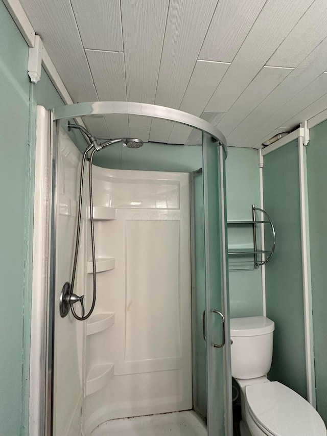 bathroom with toilet and a shower with shower door