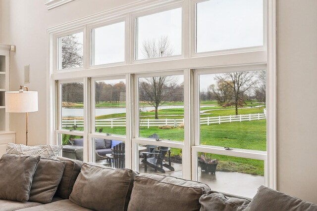 doorway to outside with a water view and a high ceiling