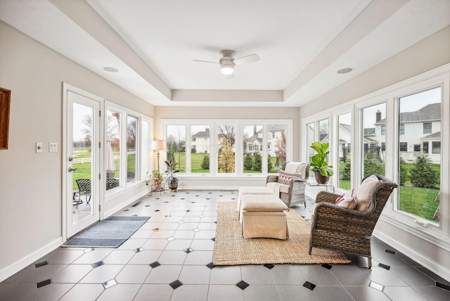 sunroom featuring a tray ceiling and ceiling fan