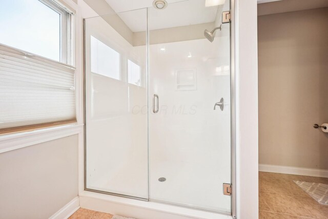 bathroom featuring tile patterned flooring and a shower with door