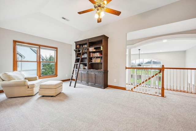 living area featuring carpet flooring, ceiling fan, a healthy amount of sunlight, and lofted ceiling