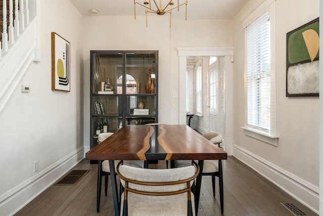 dining room with plenty of natural light, dark hardwood / wood-style floors, and a notable chandelier