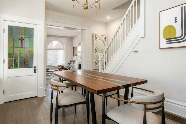 dining space with dark hardwood / wood-style floors and a chandelier