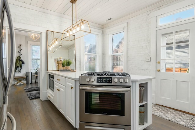 kitchen featuring appliances with stainless steel finishes, white cabinets, pendant lighting, a chandelier, and dark hardwood / wood-style floors