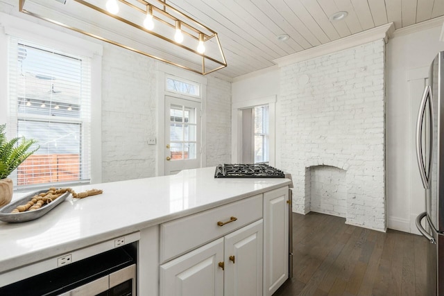 kitchen with white cabinetry, beverage cooler, stainless steel appliances, dark hardwood / wood-style flooring, and ornamental molding