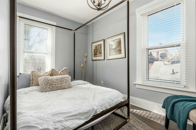 bedroom featuring an inviting chandelier and hardwood / wood-style flooring