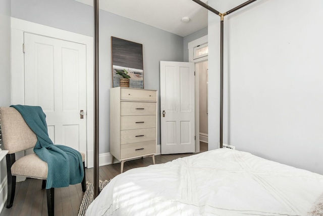 bedroom with dark hardwood / wood-style flooring and a closet